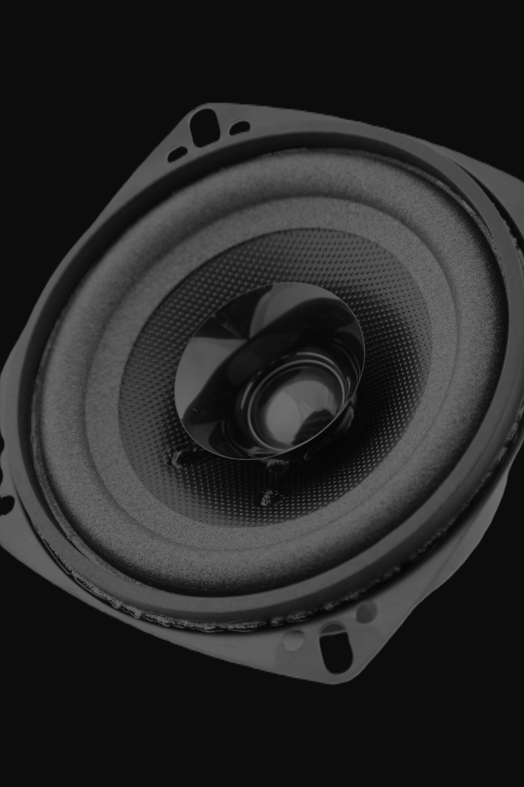 Close up of speaker with a cone shape centre.